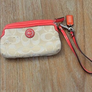 Coach Poppy signature monogram canvas wristlet with pink trim.